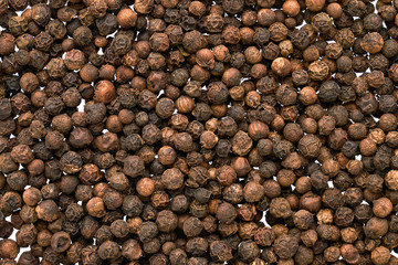Black peppercorn background. View from above