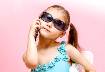 little girl on a pink background talking on the phone