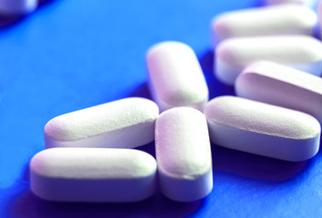 White pills on blue background. medicine theme