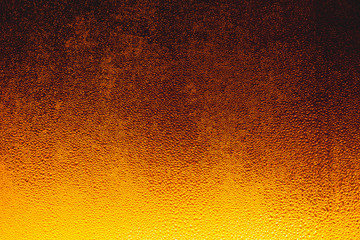 Drops on the glass,Bottle with a cold drink. Thin layer of ice on the glass surface. On a black background