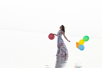 motivation or hope concept, follow your dream and inspiration, girl with balloons at sunset with sea 