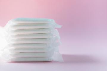 Feminine sanitary napkin, an absorbent item worn by a woman while menstruating, on pink background for hygiene and health concept
