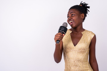 Happy young beautiful African woman singing with microphone