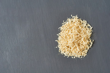 Heap of wooden sawdust on dark concrete surface in carpentry workshop