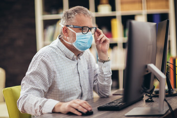 Business man working from home, wear a protective mask. Quarantine due coronavirus pandemic. Stay at home.