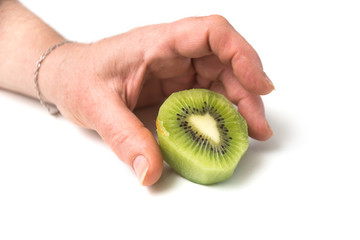 Closeup of sliced kiwi fruit in shaped heart in hand of woman on white background