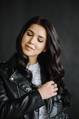 Naklejka premium Photo of smiling brunette business woman on black background, Charming sweet girl. Photography of a young cute girl