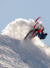 Naklejka na ściany i meble snowmobilers sports riding. Winter extreme ski-doo. an elite snowmobiler is testing a new model of mountain snowmobile, the prototype of 2021. bright snowmobile and suit. rider makes a turn and jump