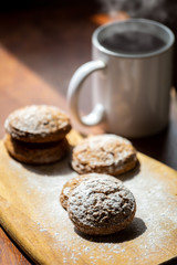 oatmeal cookies on a wooden board next to a mug of hot drink