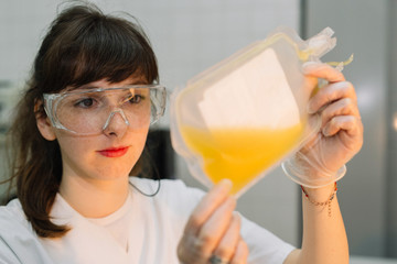 A healthcare examines a plastic bag with blood plasma