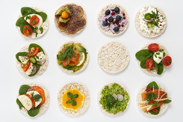 set of rice cakes on white background.  food rice cake sandwich isolated on white background. Rice cakes with Basil, tomatoes, avocado, cheese and red trout or salmon fish, mozzarella cheese, cucumber