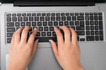 Computadora en trabajo con unas manos escribiendo una historia