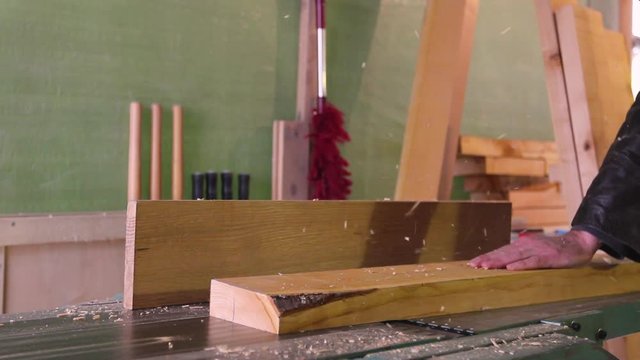 Carpenter works on circular saw, woodworking machine in the carpentry workshop 