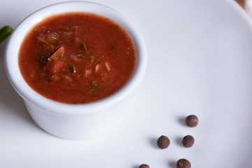 Satsebeli homemade sauce in a bowl isolated on a white plate background. Dish of Georgian cuisine

