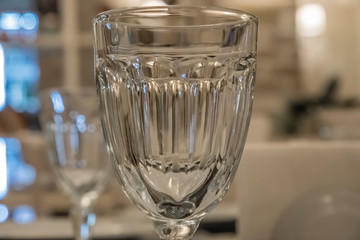 : The served table in the restaurant. Clean dishes and appliances on the tablecloth in a cafe. Shiny transparent glasses. White plates. Prepared for the reception of guests. High service.