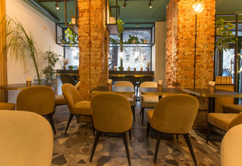 Cute restaurant interior with sofas and wooden tables