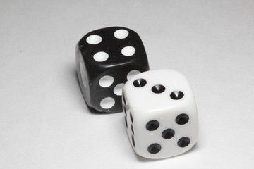 Two dice on a white background. White and black dice on a white background. Isolated dice close up.