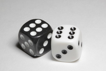 Two dice on a white background. White and black dice on a white background. Isolated dice close up.