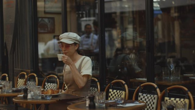 Young girl drinking coffee in a cafe in Paris