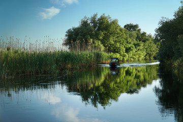 Boat on a deep water channel in the Danube Delta in Romania near Crișan.  