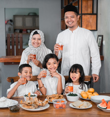 muslim asian family breaking the fast together having some sweet drink