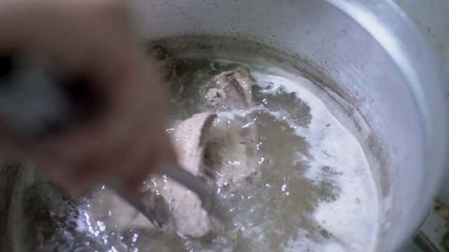 Close up scene of cooking Bak Kut Teh by boiling pork ribs in herb ribs stock soup, food processing, Malaysian and Singaporean Traditional dish, cooking step, food preparation, one of the famous dish.