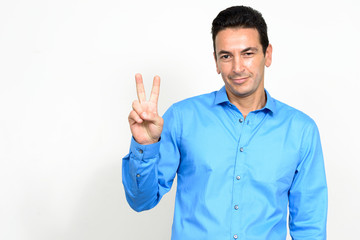 Portrait of mature handsome businessman with peace sign