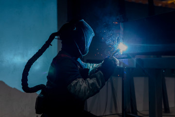 man is metal welding on factory