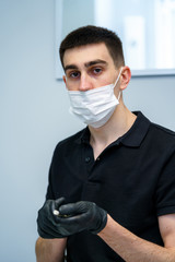 Portrait of a doctor or medical specialist. Vertical portrait. Man in scrubs. White background. Doctor in face mask.