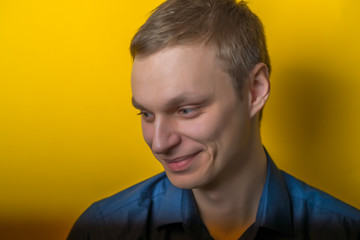 Obraz premium Blond young man smiles sweetly. Isolated yellow background. photo