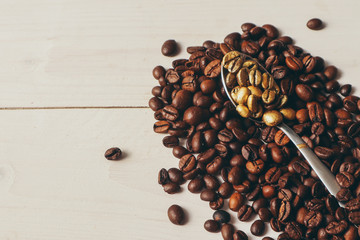 Scoop with golden coffee grains on light background