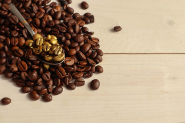 Scoop with golden coffee grains on light background