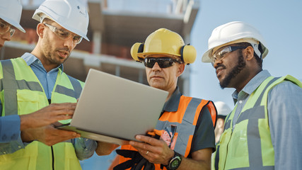 Diverse Team of Specialists Use Laptop Computer on Construction Site. Real Estate Building Project with Civil Engineer, Architectural Investor, Businesswoman and Worker Discussing Blueprint Plan