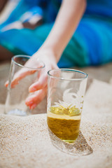 Glasses with a drink on the sand