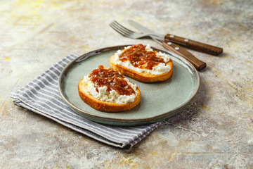 Canape or crostini with toasted baguette, cottage cheese, fig jam