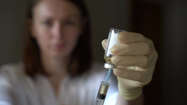 Self-injection of antibiotics. Female preparing needle for injecting her buttocks. Woman injecting buttocks.