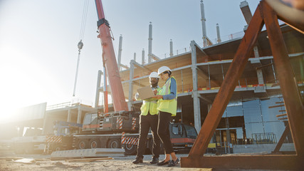 Two Specialists Inspect Commercial, Industrial Building Construction Site. Real Estate Project with...