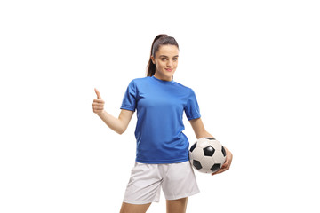 Female football player holding a soccer ball and showing thumbs up