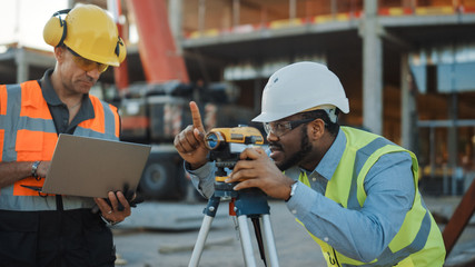 On the Commercial / Industrial Building Construction Site: Professional Engineer Surveyor Takes...