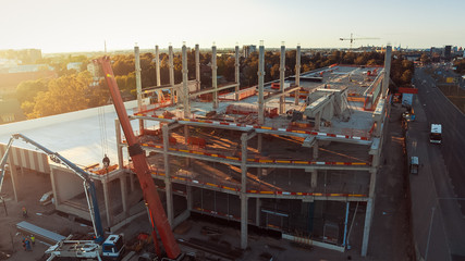 Naklejka premium Aerial View of Industrial / Commercial Property Building Construction Site. Machinery and Skyscraper Concrete Formwork Frame with in the Sunrise