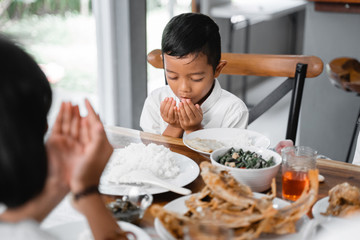 asian children pray muslim open arm before eating dinner