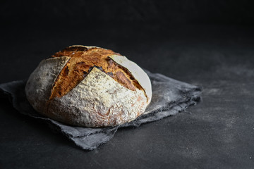 .Bread. Homemade whole grain bread on a dark napkin on a dark background copy space.