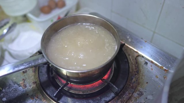 Close up scene of cooking Bak Kut Teh by boiling garlic in the herb ribs stock soup, food processing, Malaysian and Singaporean Traditional dish, cooking step, food preparation, one of the famous dish