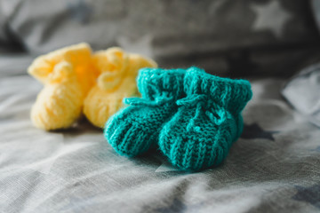 Fototapeta na wymiar Mint and yellow knitted booties for a child.