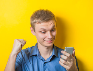Closeup portrait of handsome young man, shocked surprised guy, opened mouth, eyes, by what he sees on his cell phone, isolated on white background. Negative human emotions, facial expressions, feeling
