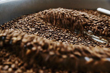 Coffee brown roasted beans. The roasting process in the roaster