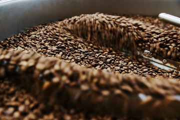 Obraz premium Coffee brown roasted beans. The roasting process in the roaster
