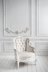 Fototapeta na wymiar White leather chair. Large mirror with artificial flowers