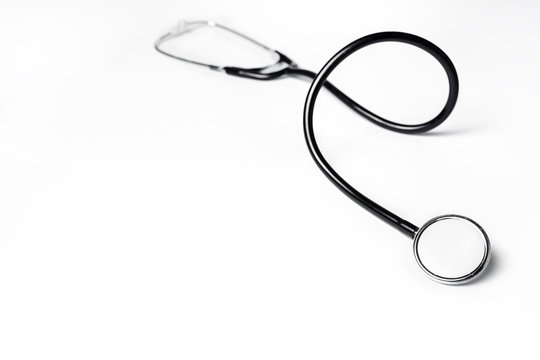 Photo of black medical stethoscope over white background.