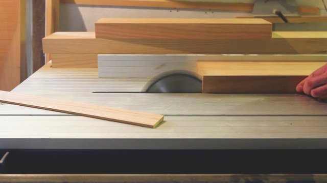 Carpenter works on circular saw, woodworking machine in the carpentry workshop 